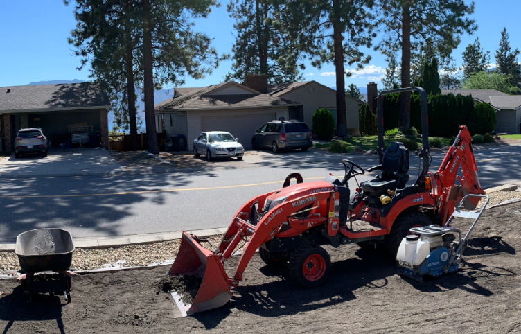 Vview of an excavator working on a property with houses in the background